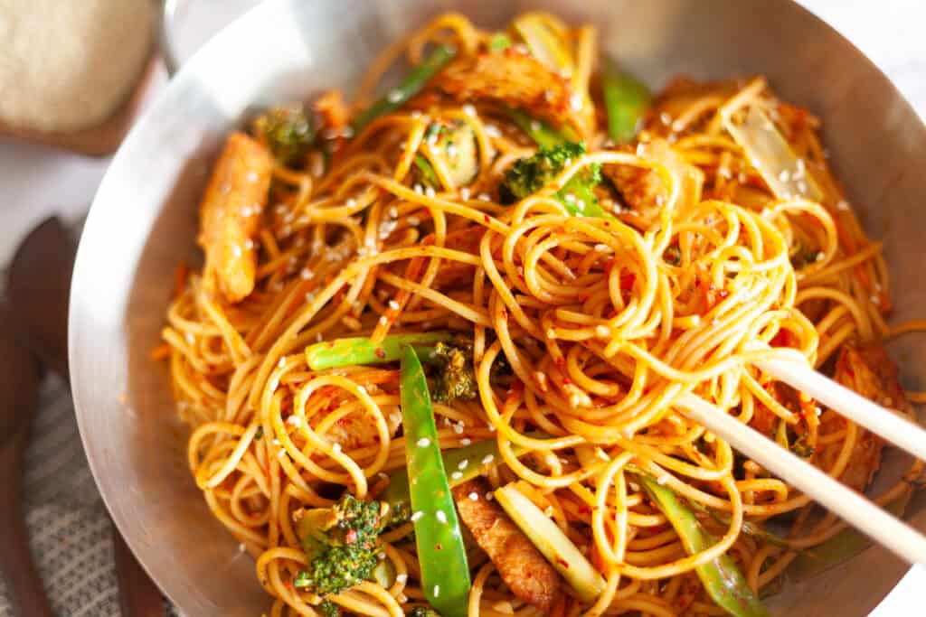 Thai peanut sauce stir fry noodles in a pan with chopsticks