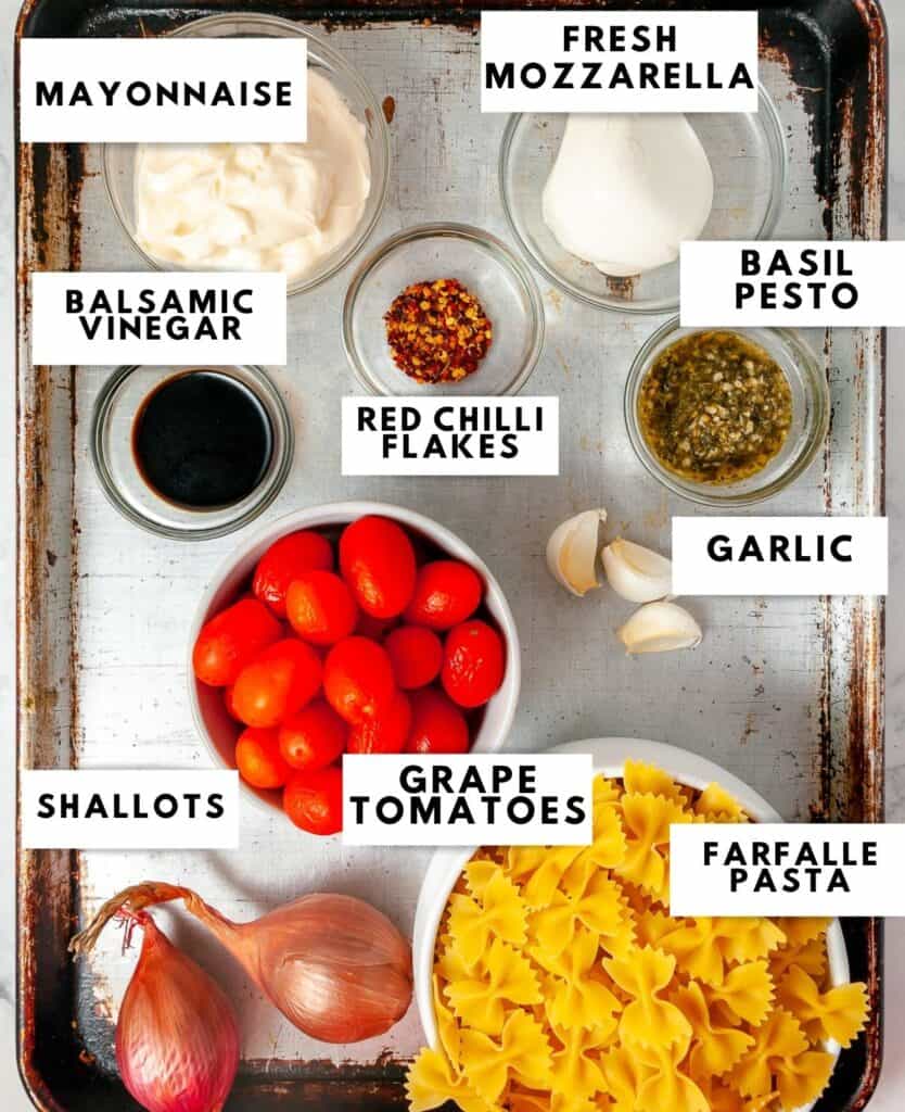 Ingredients for pasta salad laid on a sheet tray and labelled