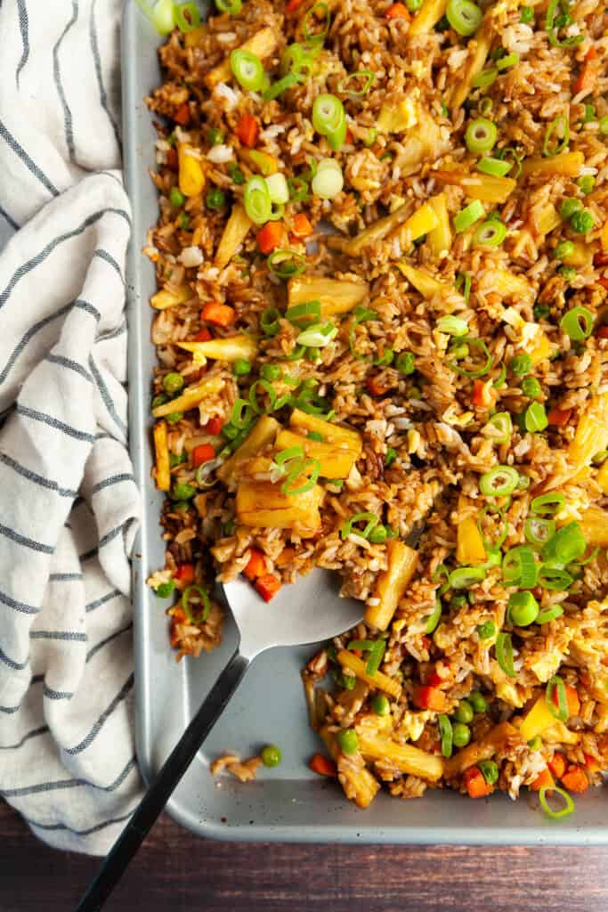 Sheet pan pineapple fried rice with a serving spoon