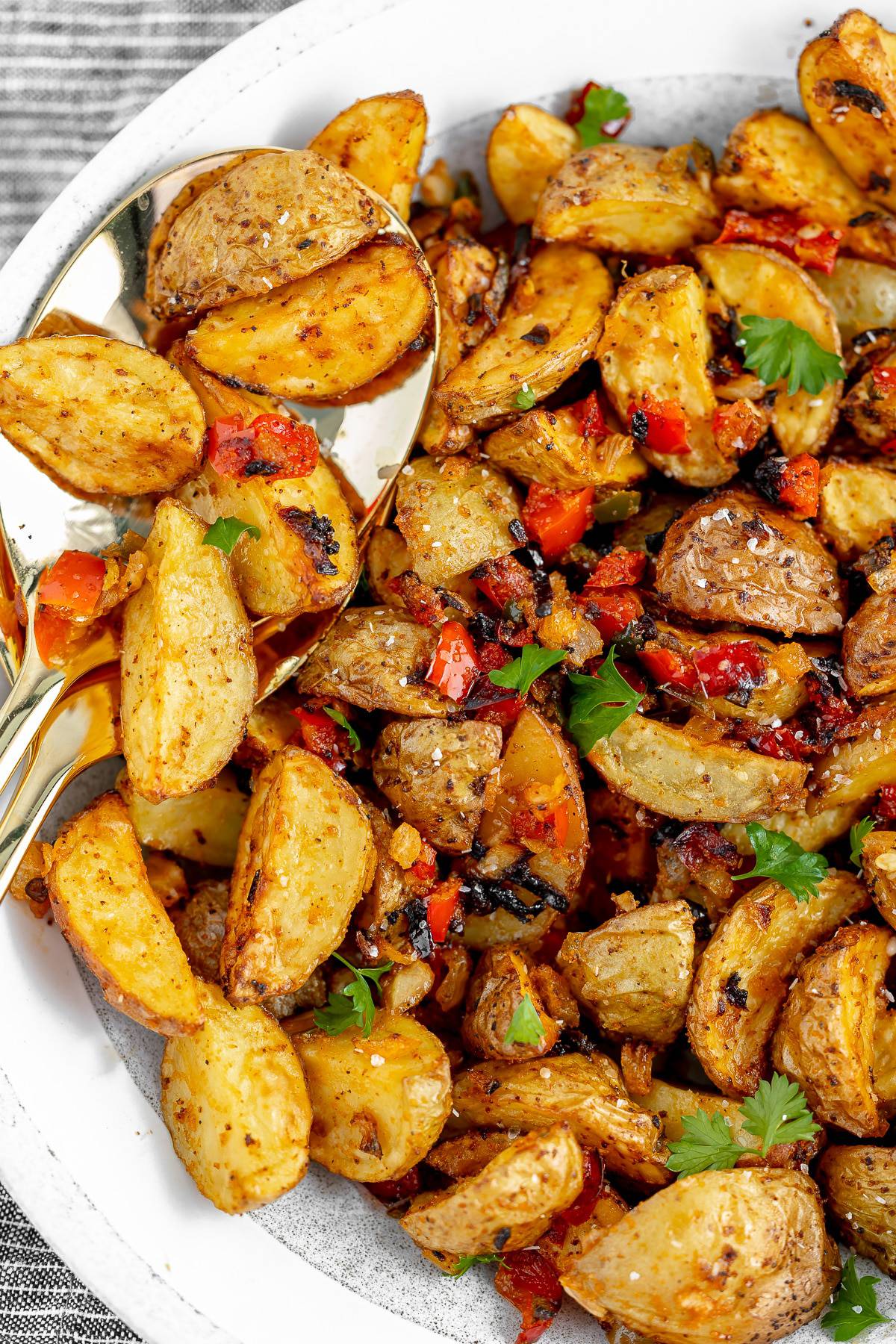 Southern home fries in a plate, with two serving spoons.