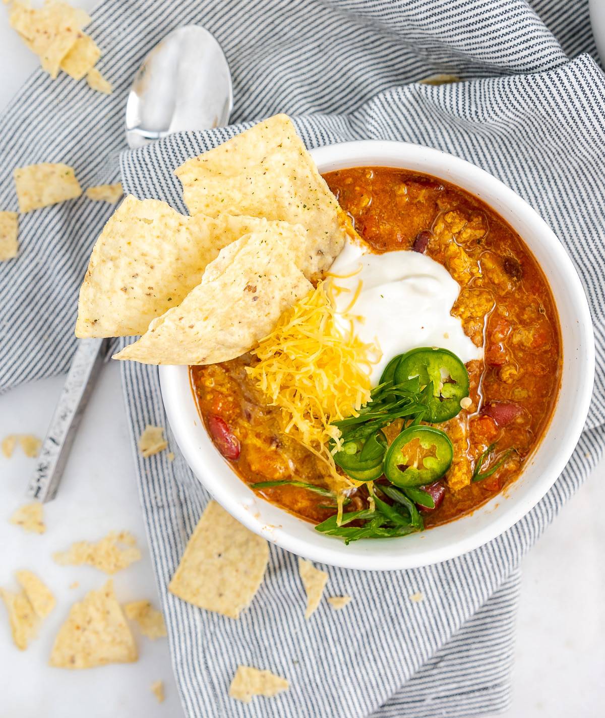 Texas chili in a bowl with fixings - cheese, jalapeno, and sour cream. 