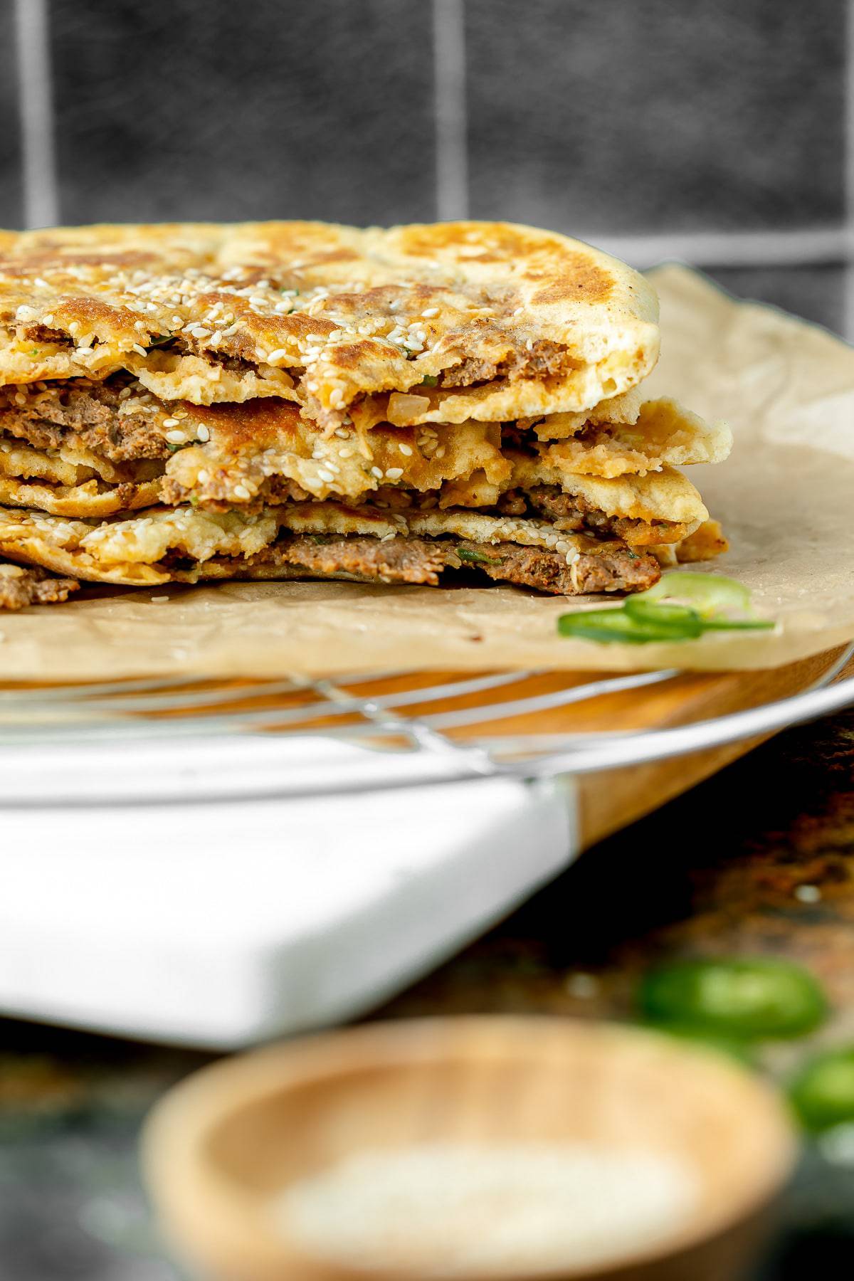 Keema naan cut in half and stacked, served on a serving board.