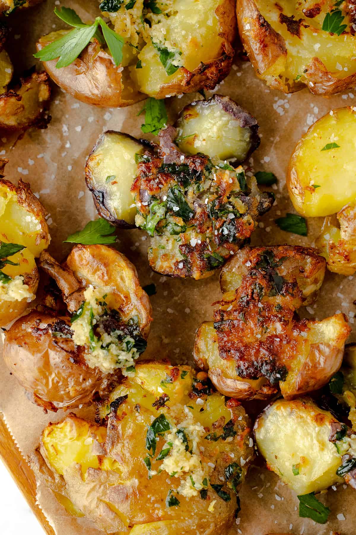 Air fryer smashed potatoes served on a board with parchment paper.