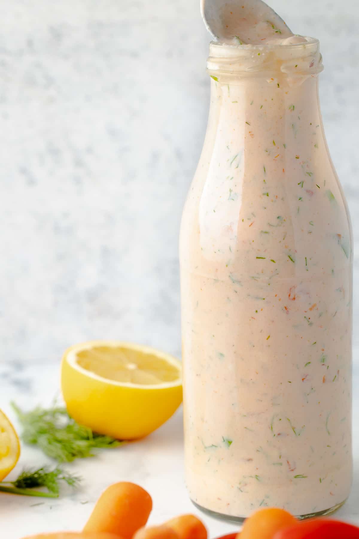 Salsa ranch dressing in a bottle, with a spoon showing the texture. 