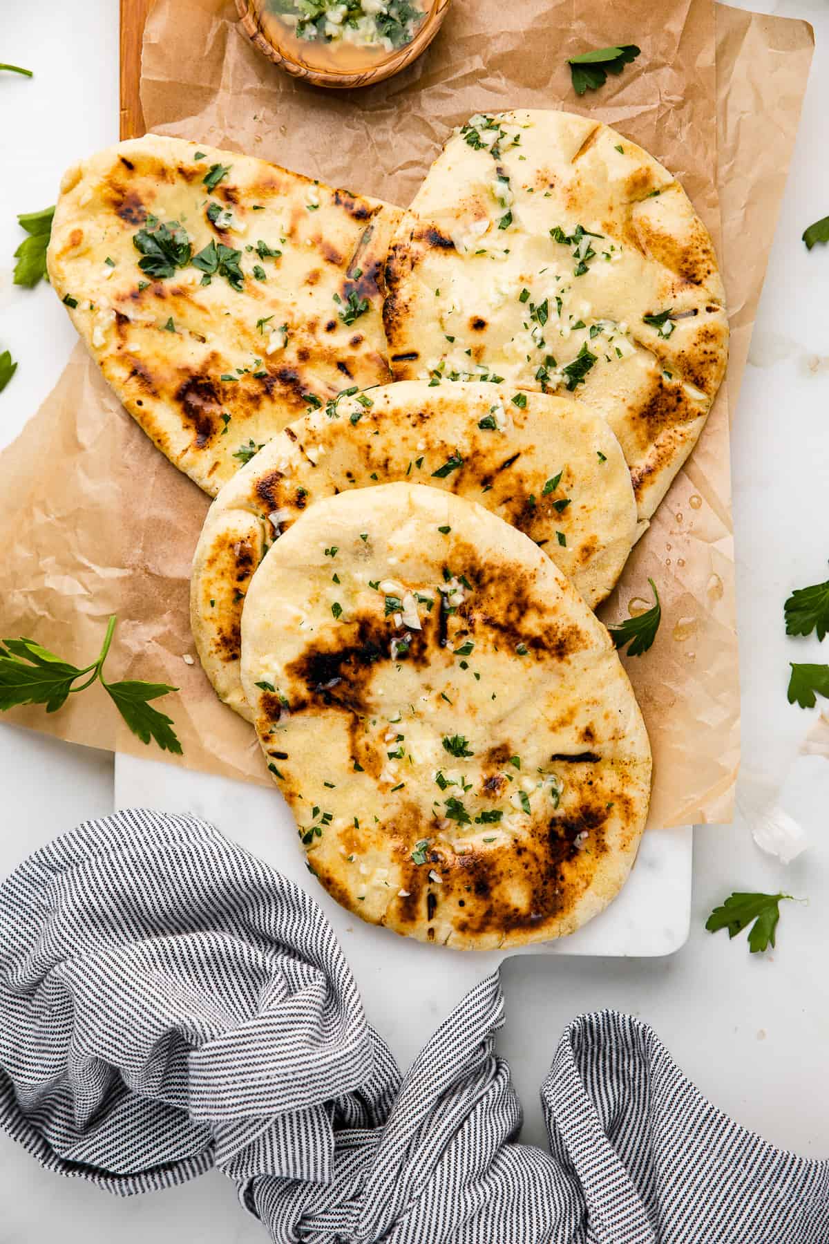 Stuffed cheese naan served on a board, garnished with cilantro. 
