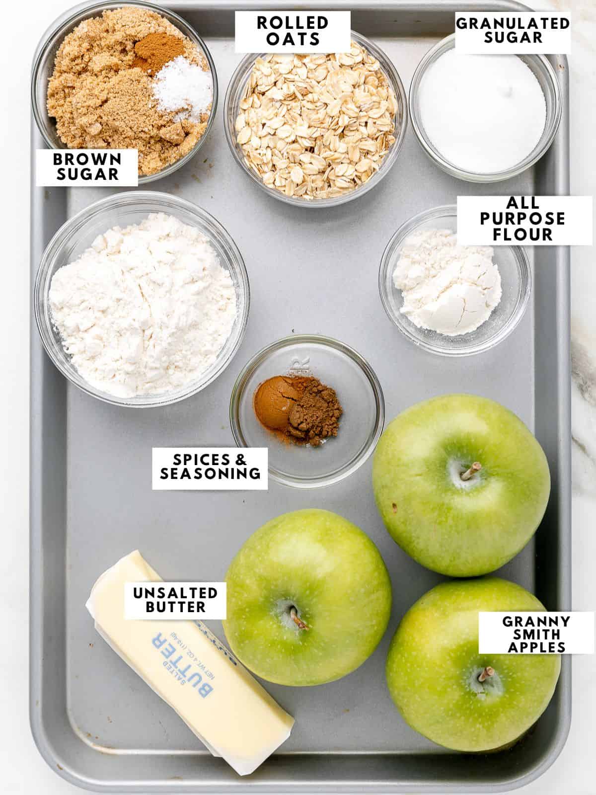 Ingredients for apple crumble, labelled on a sheet tray. 