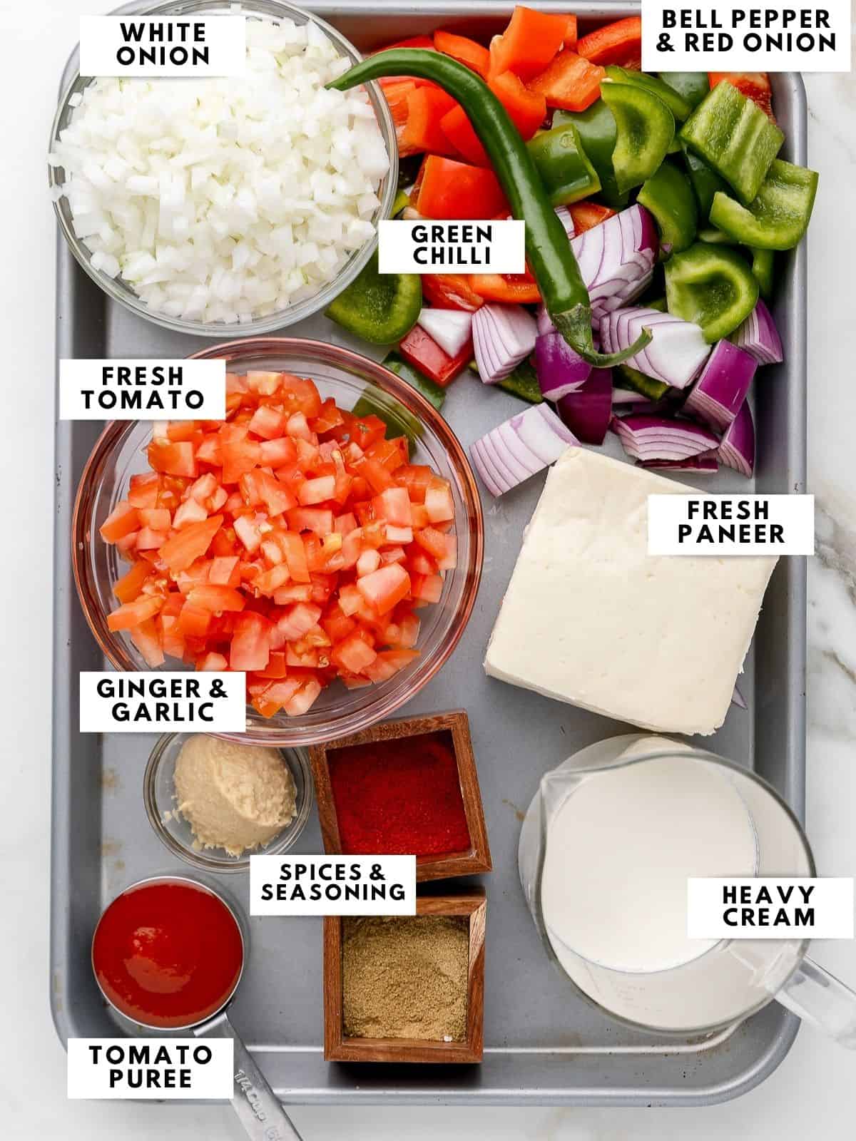 Ingredients for kadai paneer, labelled on a sheet tray. 