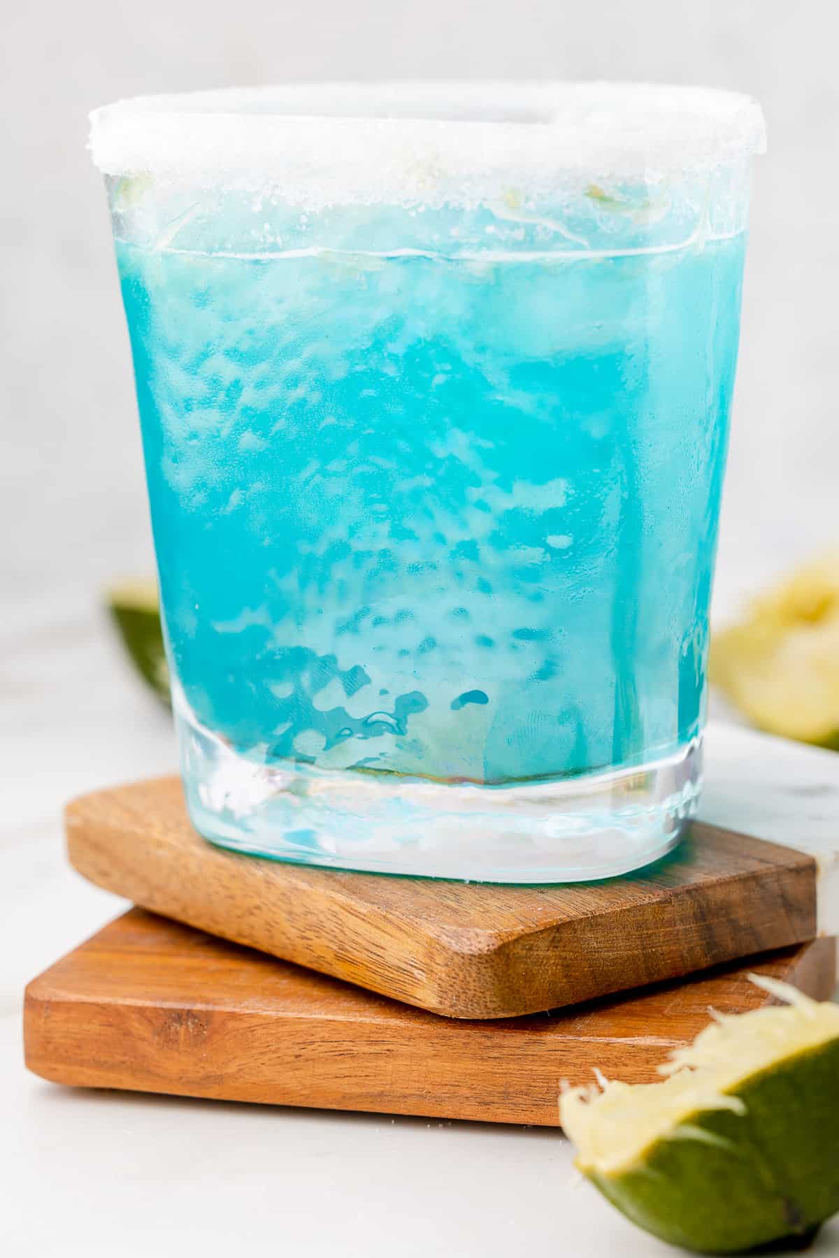 Straight-on shot of margarita azul in a glass, rimmed with sugar. 