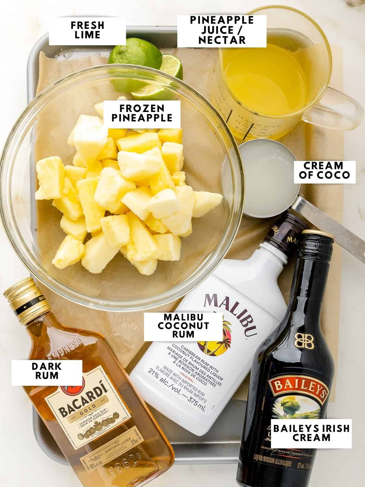 A photo of all ingredients: Frozen pineapple, cream of coco, malibu coconut rum, dark rum, bailey's irish cream, pineapple juice or nectar, and fresh lime