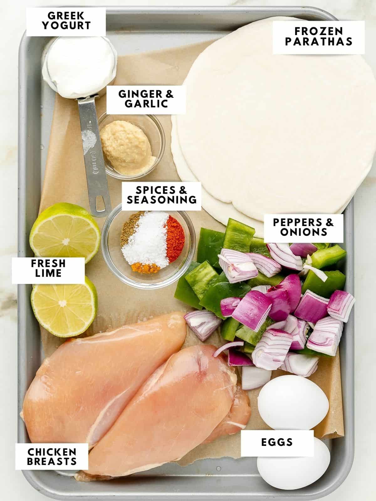 Ingredients to make chicken kathi rolls, labelled on a sheet tray.