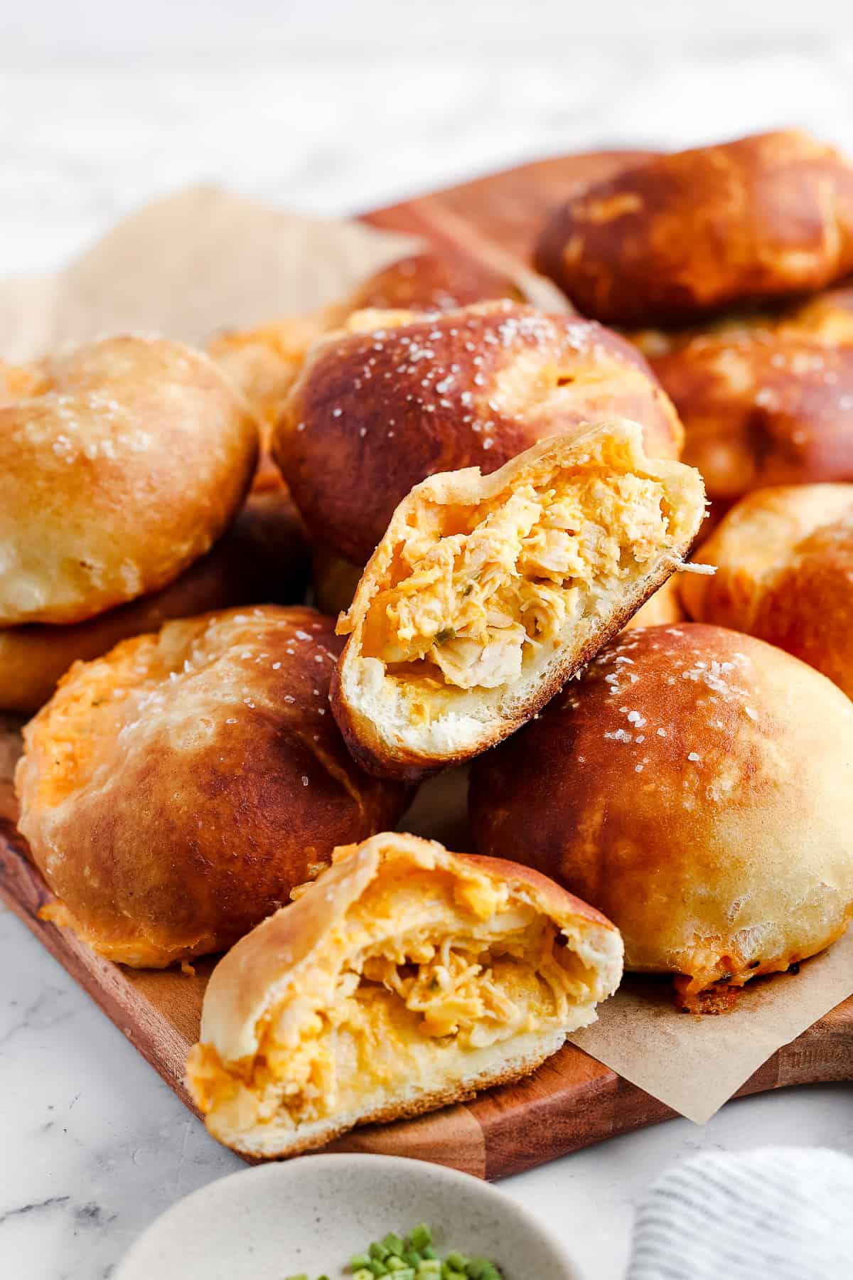 Buffalo pretzel bites arranged on a serving board, with one cut open to show the filling.