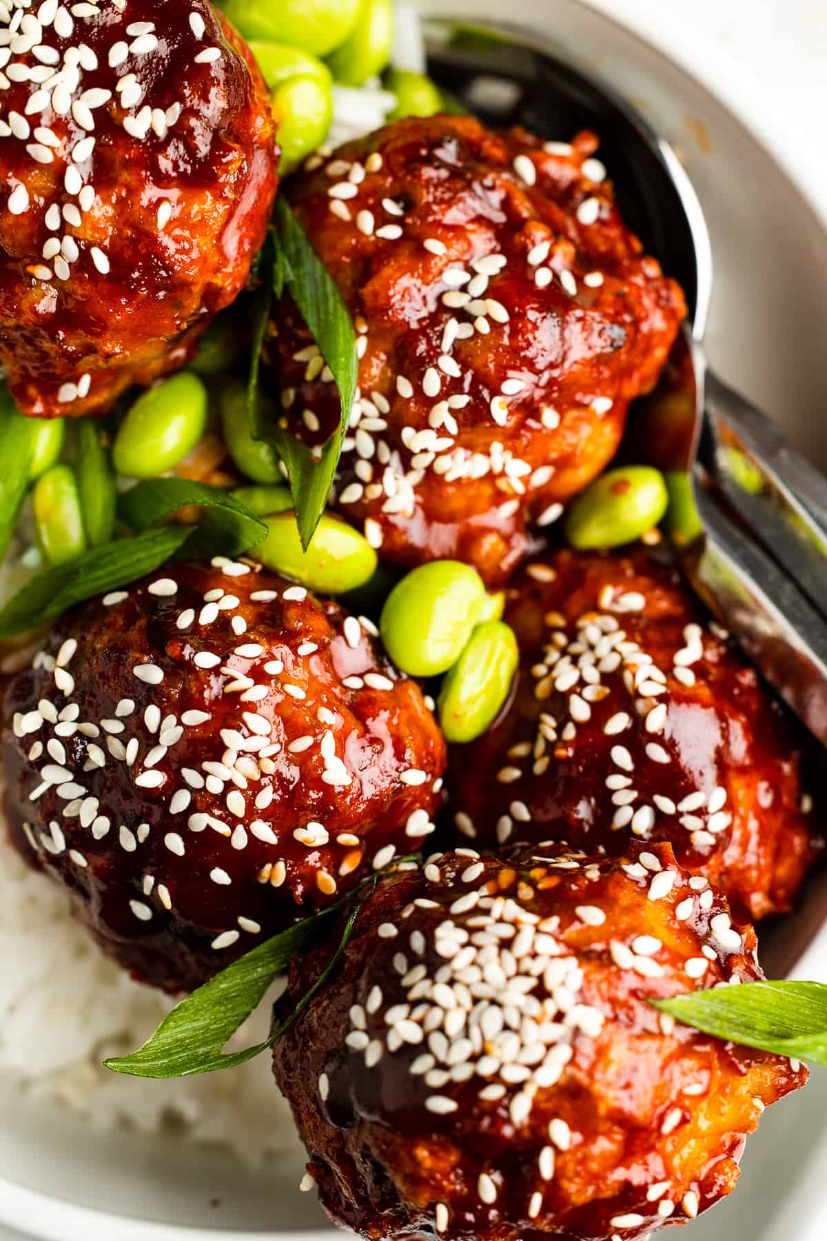 Close-up shot of Korean chicken meatballs, garnished with sesame seeds.