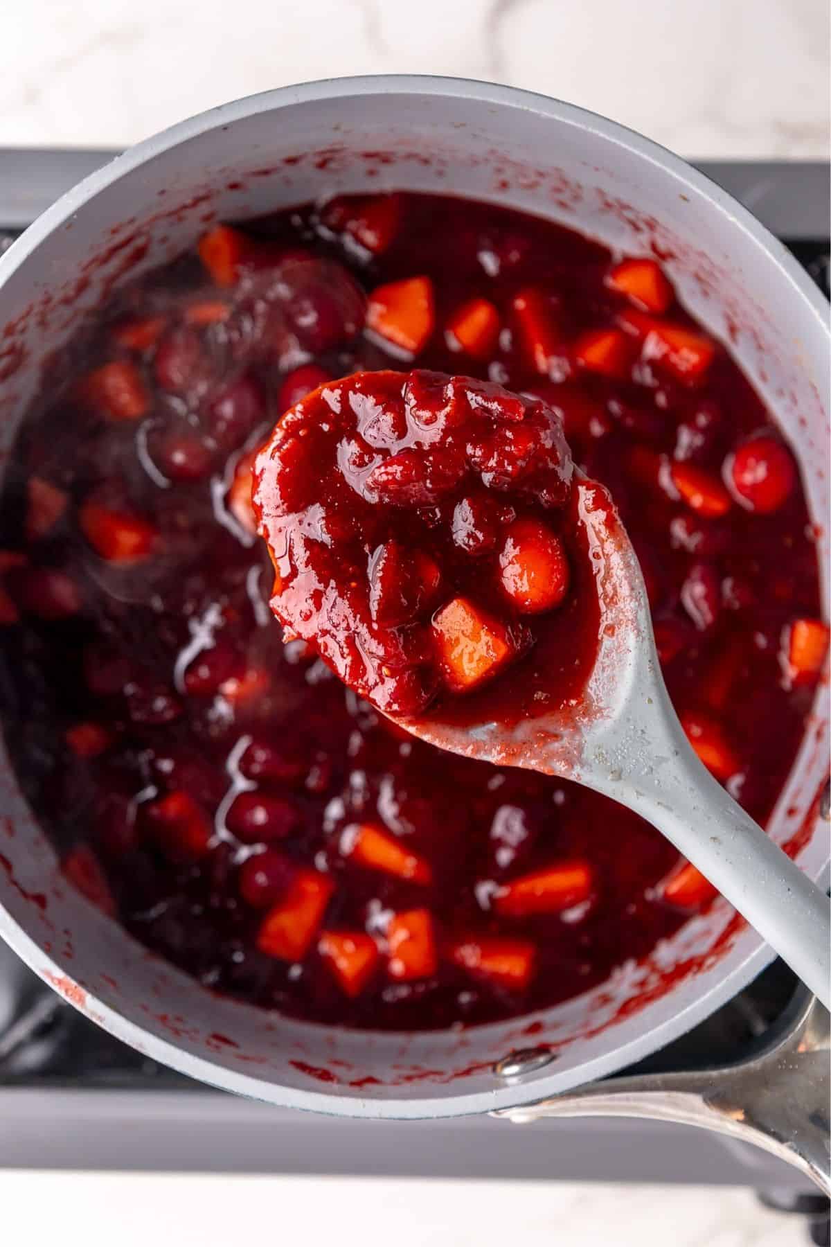 Spoon showing the texture of thickened cranberry sauce. 