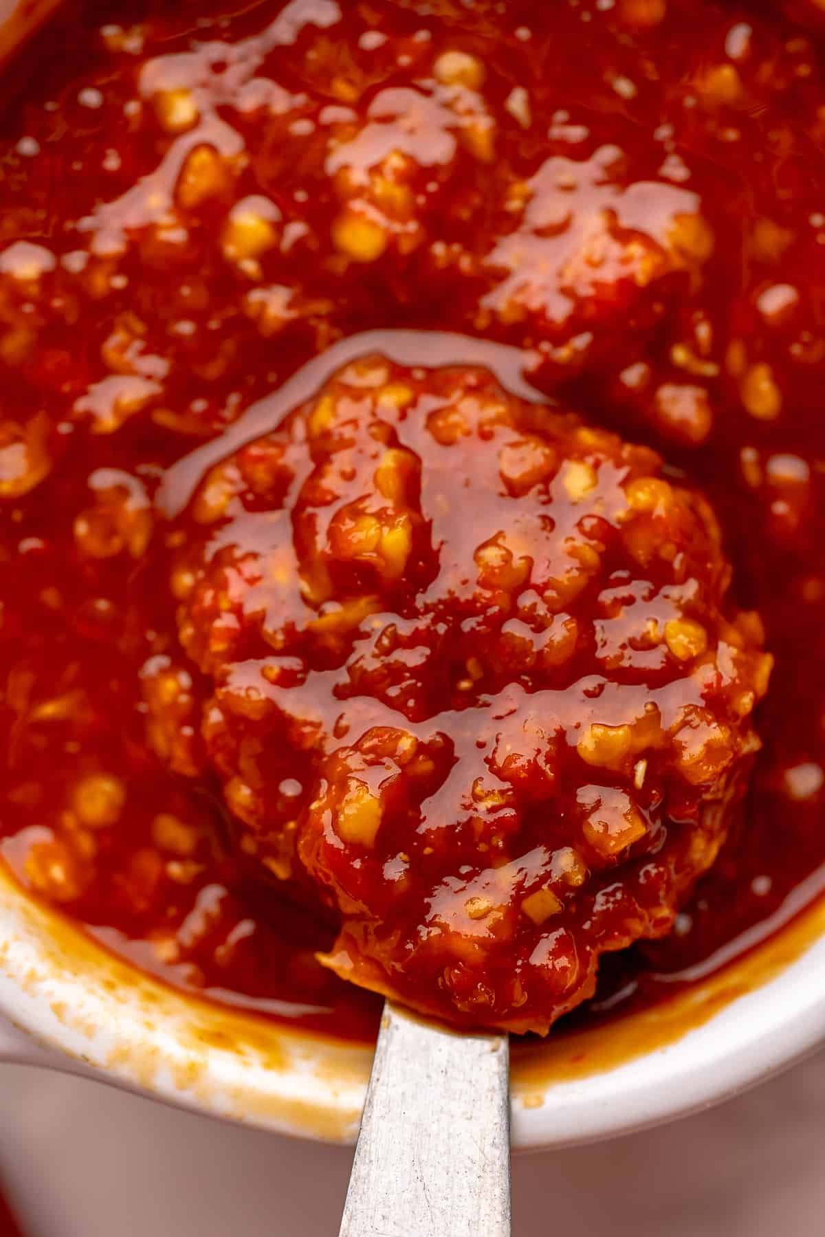 Close-up shot of finished sauce, with a spoon showing the texture of the sauce.