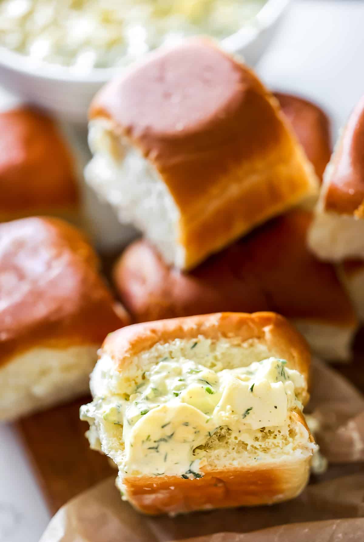 Egg salad served in a mini brioche bun, with a pile of buns.