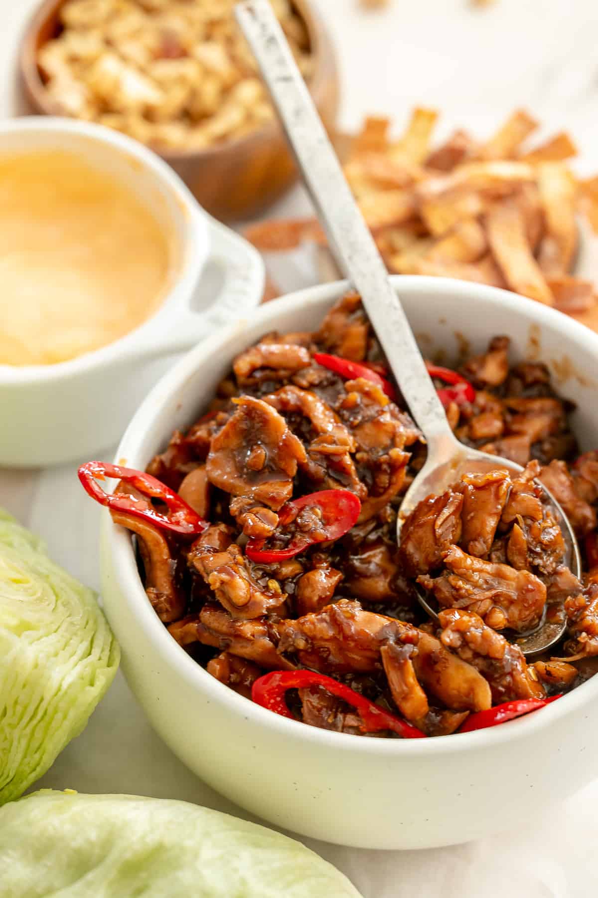 Szechuan chicken served in a bowl, with lettuce served on the side for wraps.